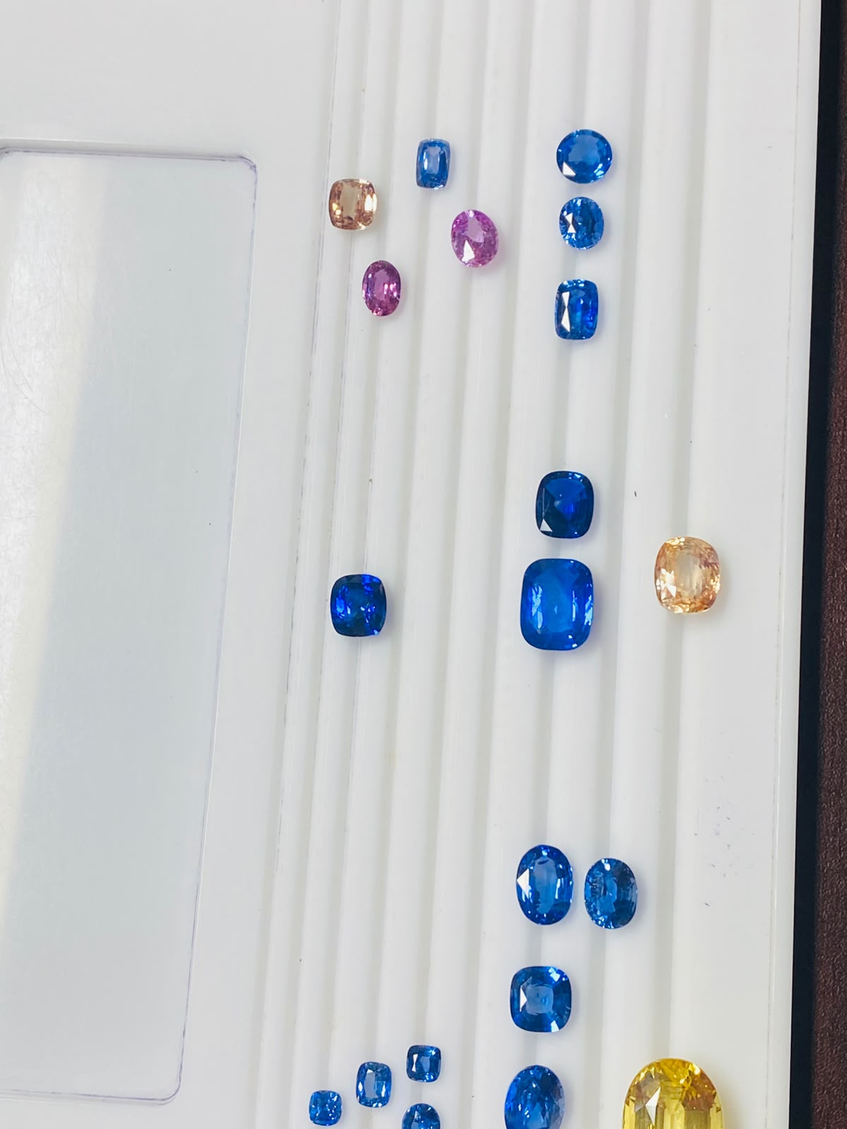 Supplied loose gemstone assortment on a white presentation tray; individual identities and origins to confirm